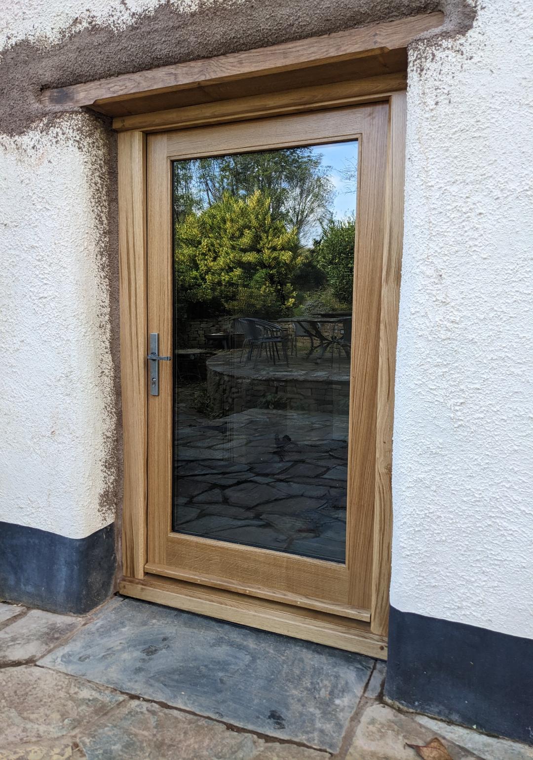 Bespoke air-dried oak glazed rear door with traditional oiled finish installed in a listed farmhouse.