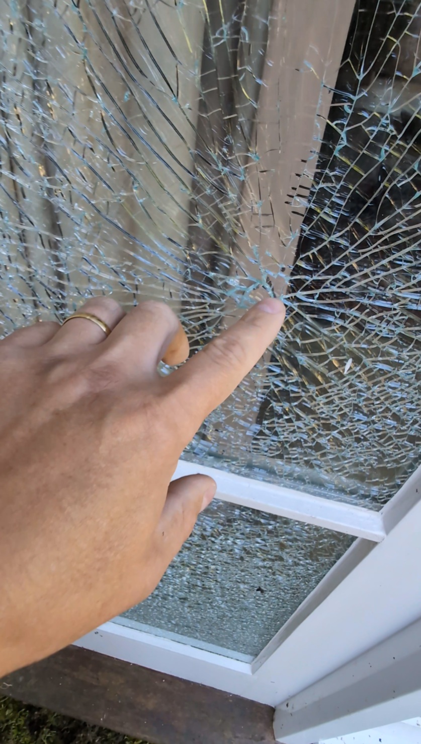 Broken outer pane of a double glazed unit in a timber entrance door before replacement on a property in Exmoor