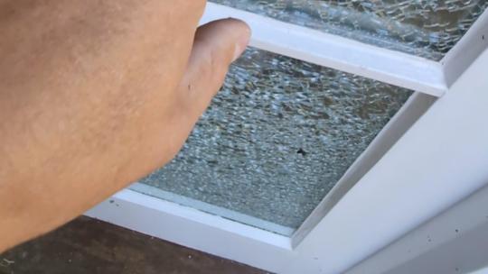 Broken outer pane of a double glazed unit in a timber entrance door before replacement on a property in Exmoor