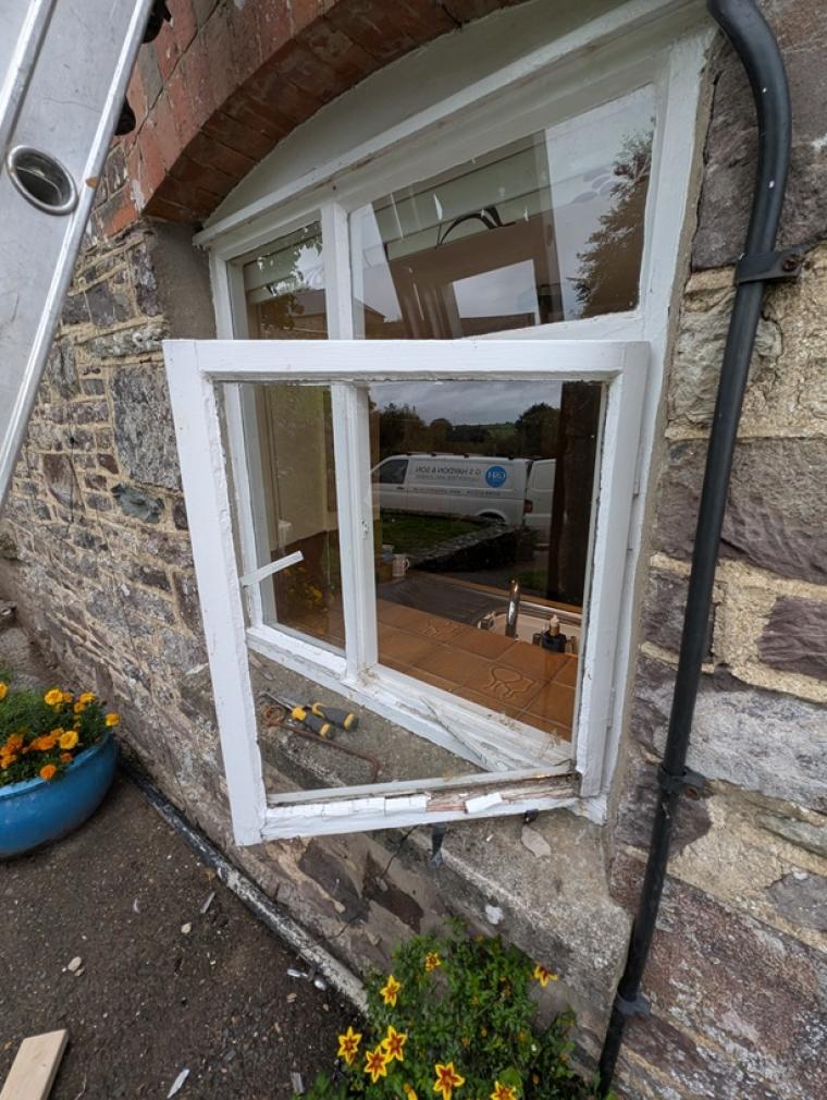 Old timber window being removed from a traditional stone property in Devon